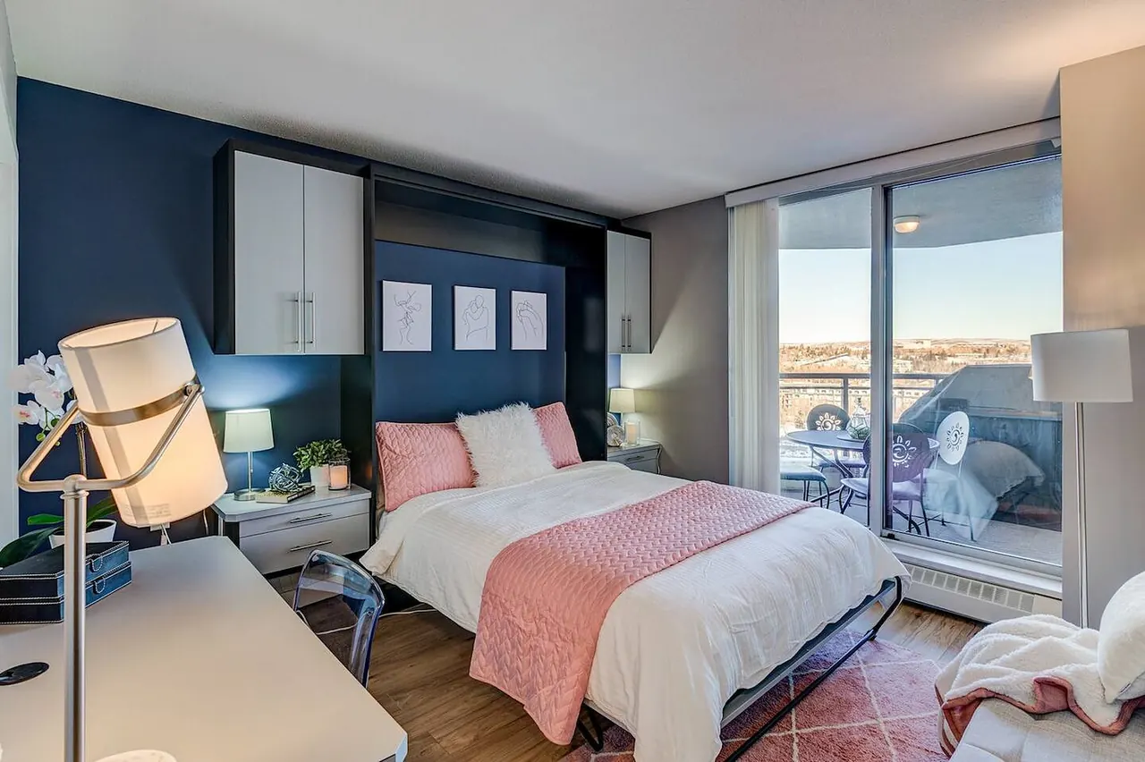 Second bedroom with the Murphy bed down and a sliding door to the balcony